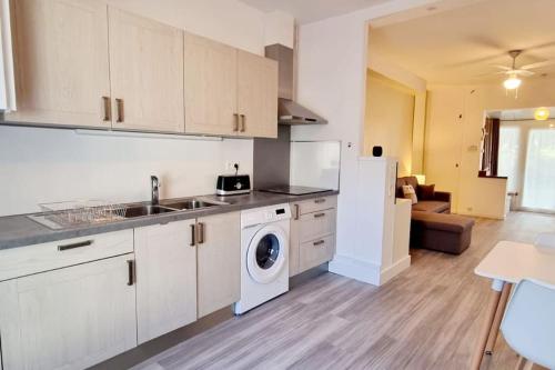 une cuisine avec un évier et une machine à laver dans l'établissement La Maison de la Plage, à Argelès-sur-Mer