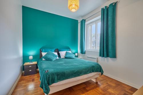 une chambre bleue avec un lit et une fenêtre dans l'établissement Gîte des Mascarets - Appt pour 4, à Pont-Audemer