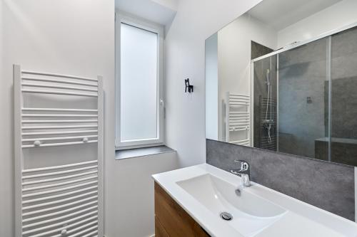 une salle de bain blanche avec un lavabo et une douche dans l'établissement Gîte des Mascarets - Appt pour 4, à Pont-Audemer