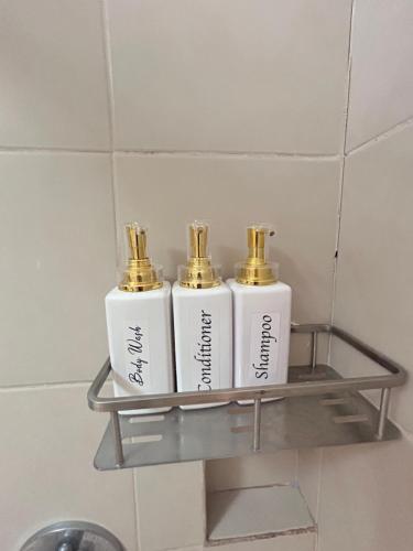 two white bottles on a shelf in a bathroom at Bristle Ridge Bluebird 103 Baguio City in Baguio