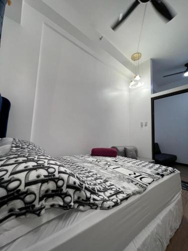 a bedroom with a bed with a black and white blanket at Bristle Ridge Bluebird 103 Baguio City in Baguio