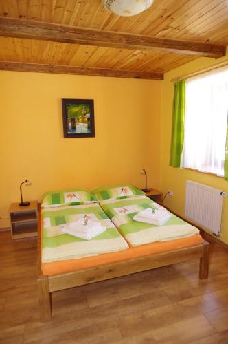 a bedroom with a large bed with yellow walls at Ubytování a apartmány Sluníčko in Lomnice nad Lužnicí