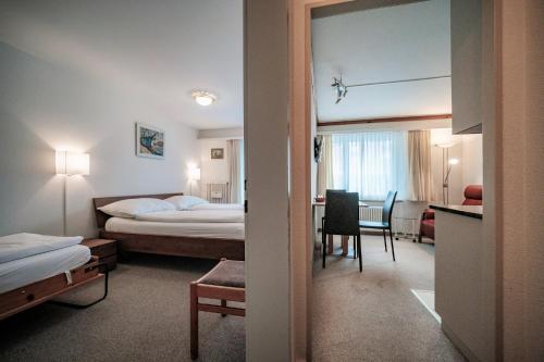 a hotel room with a bed and a table at Paradies 012 in Arosa