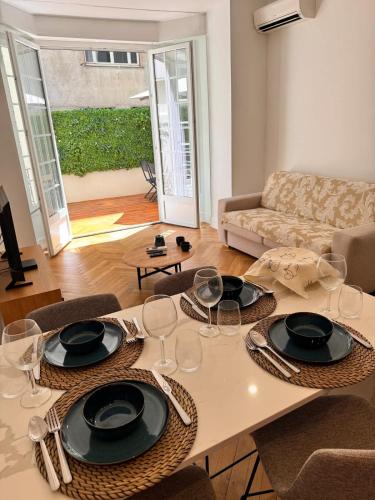 - un salon doté d'une table avec des assiettes et des verres à vin dans l'établissement Luxury Central Condo with Private Terrace in Nice, à Nice