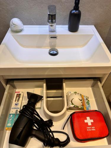 - un lavabo blanc et un sac rouge sous une table dans l'établissement Luxury Central Condo with Private Terrace in Nice, à Nice