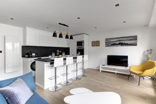 Il comprend une cuisine et un salon avec un bar et des chaises. dans l'établissement Suite Dolce Vita - Superbe Appartement, à Suresnes