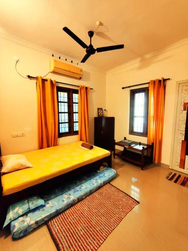 a bedroom with a large bed with orange curtains at Jambavan Arts Sanctuary in Varkala