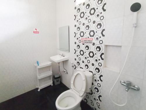 a small bathroom with a toilet and a sink at RedDoorz at Wisma Garden Purwokerto in Purwokerto