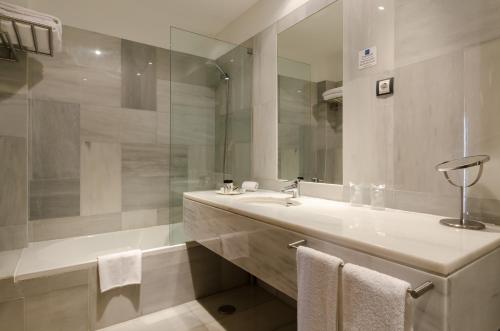 a white bathroom with a sink and a mirror at Hotel Principe Real in Lisbon
