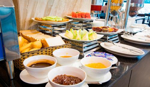 een buffet met kommen en borden met eten bij CCT Luxury Hotel in Nha Trang