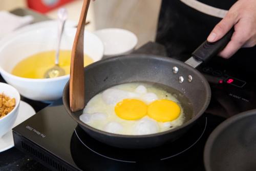 Twee eieren worden in een pan op het fornuis gebakken. bij CCT Luxury Hotel in Nha Trang