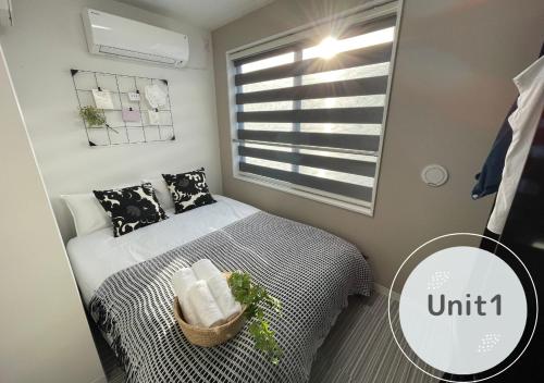 a small bedroom with a bed and a window at COMMA HOUSE Shinjuku 2UNITS 2122 in Tokyo