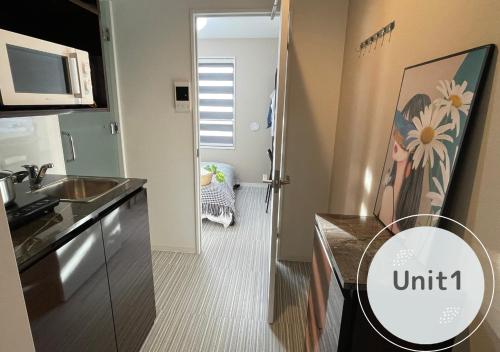 a small kitchen with a sink and a microwave at COMMA HOUSE Shinjuku 2UNITS 2122 in Tokyo