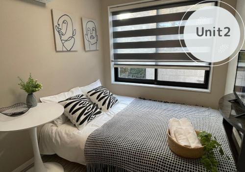 a small bedroom with a bed and a window at COMMA HOUSE Shinjuku 2UNITS 2122 in Tokyo