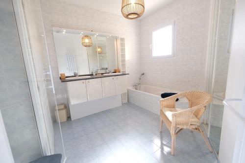 La salle de bains est pourvue d'une baignoire, d'un miroir et d'une chaise. dans l'établissement villa avec piscine aureille alpilles paragi ls1-449, à Aureille
