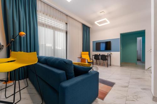 a living room with a blue couch and a yellow chair at Izzzi Life Mint in Dubai