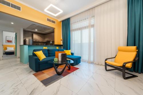 a living room with a blue couch and yellow chairs at Izzzi Life Mint in Dubai
