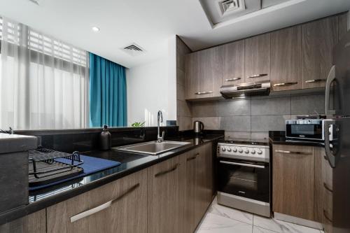 a kitchen with a sink and a stove top oven at Izzzi Life Mint in Dubai