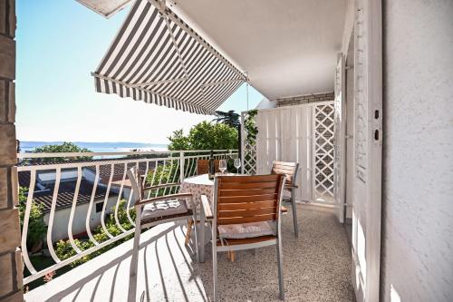 balkon ze stołem i krzesłami oraz widokiem na ocean w obiekcie Apartment Rajna w Biogradzie na Moru
