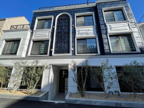 a blue and white building with a large window at COMMA HOUSE Shinjuku 2UNITS 2122 in Tokyo
