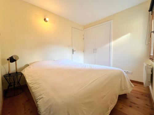 a bedroom with a white bed and a closet at T3 au cœur du centre historique de Briançon #6 in Briançon