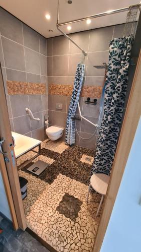 a bathroom with a shower and a toilet and a sink at Appart Hôtel Le Ptit Bec in Bègles
