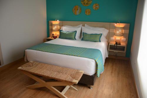 a bedroom with a large white bed and a table at bh Barranquilla in Barranquilla
