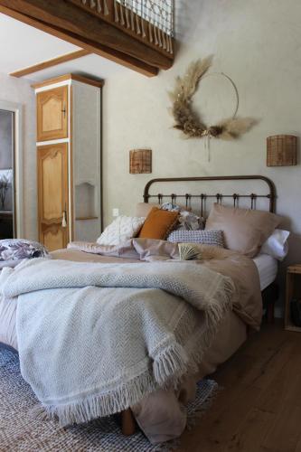 a bedroom with a large bed with blankets and pillows at Le Petit Bégou in Saint-Auban-dʼOze
