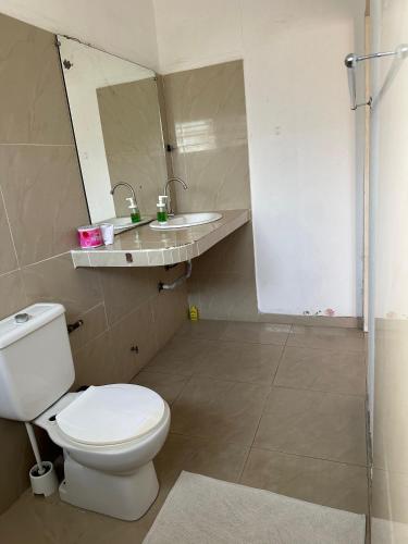 a bathroom with a toilet and a sink at La Guesthouse Étoile in Cotonou