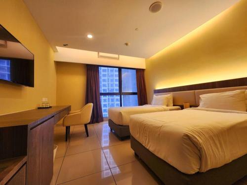 Una habitación de hotel con dos camas y un escritorio. en Ion Genting 2singlebed freeWi-fi 71612, en Genting Highlands