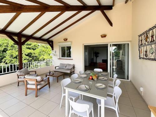 una sala da pranzo con tavolo e sedie di Bel appartement duplex T4 Laboté, vue mer, a 600m de la plage de Diamant a Le Diamant