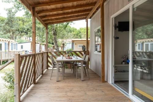 a deck with a table and chairs on it at Club del Sole Jesolo Family Resort in Lido di Jesolo