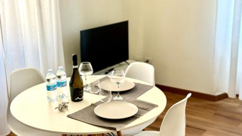 a white dining room table with wine bottles and glasses at AxelParkComo in Como