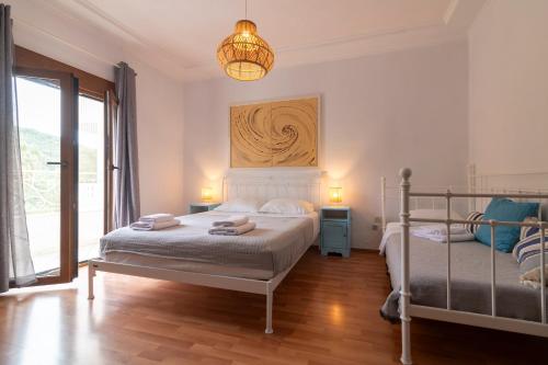 a bedroom with two beds and a chandelier at Golden Sun in Parga