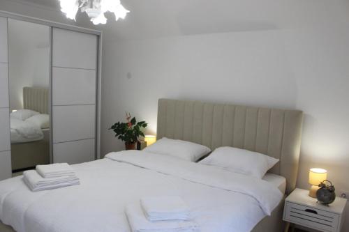 a bedroom with a white bed and a mirror at Apartmani Grot Pale in Pale