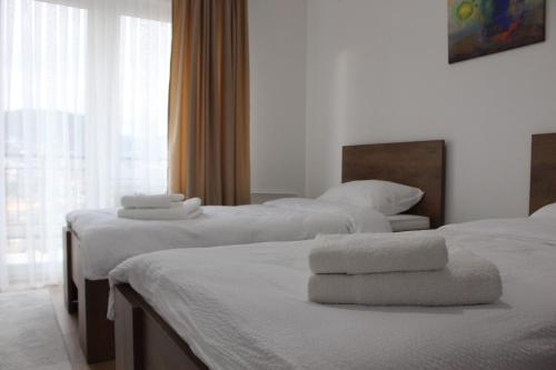 a hotel room with two beds with towels on them at Apartmani Grot Pale in Pale