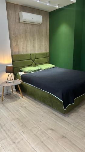 Un dormitorio con una cama grande con una pared verde. en Sky House, en Chişinău