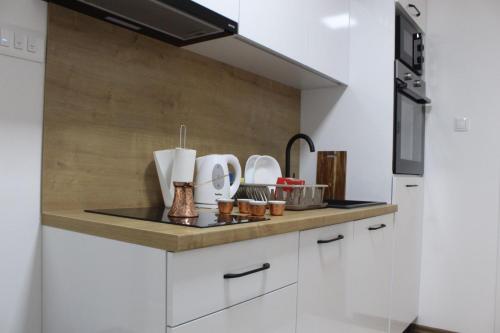 a kitchen with white cabinets and a sink at Apartmani Grot Pale in Pale