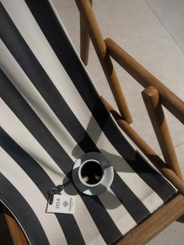 a black and white chair with a cup on it at Charisma Boutique Hotel in Parga
