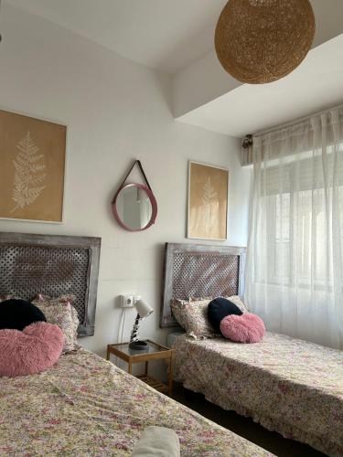 a bedroom with two beds with pink pillows at Céntrico piso con aparcamiento gratuito in Granada