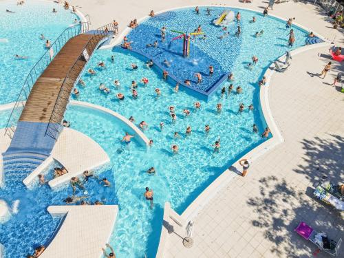 an overhead view of a swimming pool with people in it at Club del Sole Adriano Family Collection in Punta Marina