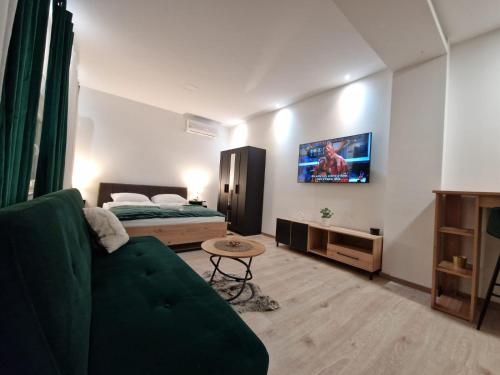 a living room with a green couch and a bed at Apartment Luxury B in Slavonski Brod