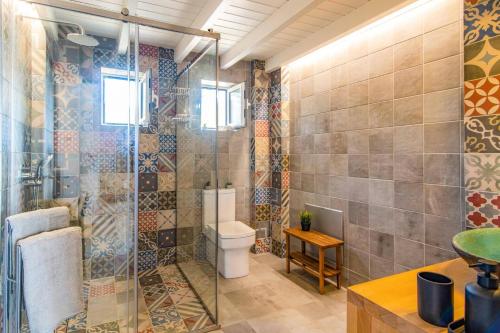 a bathroom with a toilet and a glass shower at Villa Mezzo Suite by Villa Plus in Skinária
