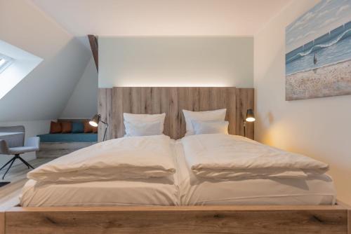 a bedroom with a large bed with a wooden headboard at Best Western Plus Theodor Storm Hotel in Husum
