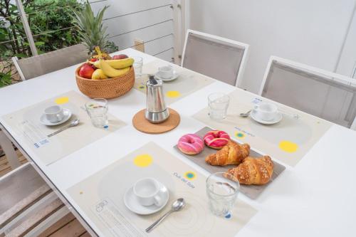 a table with a basket of fruit and pastries on it at Club del Sole Jesolo Family Resort in Lido di Jesolo