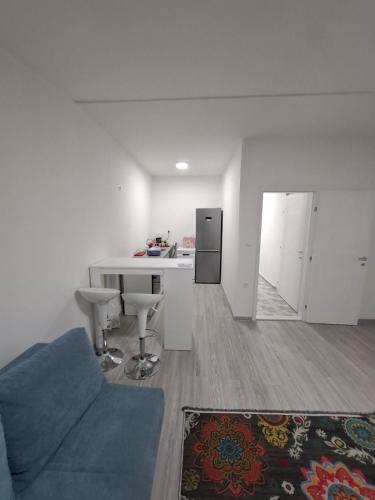 a living room with a blue couch and a kitchen at Stan na dan Djogić in Nevesinje