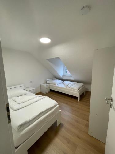 a white room with two beds and a window at Ferienwohnungen in Heidenheim in Heidenheim