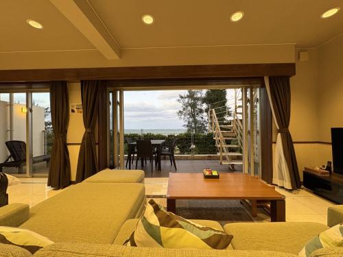 a living room with a couch and a table at Arimabaru Beach Resort in Motobu