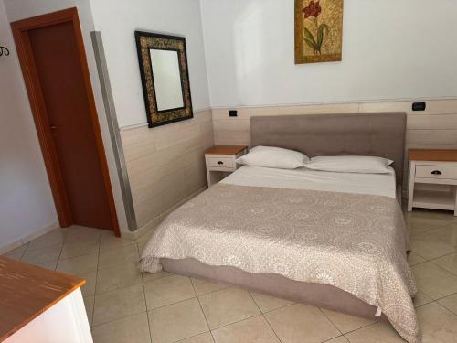 a bedroom with a bed and a mirror on the wall at Hotel VistaMare in Pozzuoli