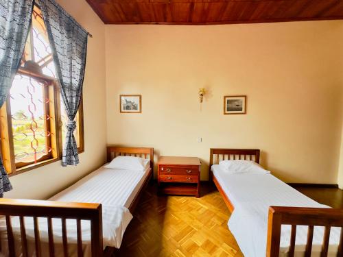 two beds in a room with a window at Starehe Villa in Arusha